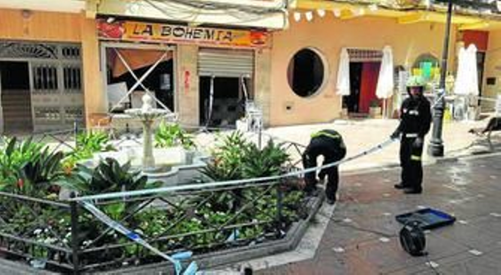 Bomberos, ayer, acordonando la fuente del pasaje Montera, dañada por la onda expansiva.