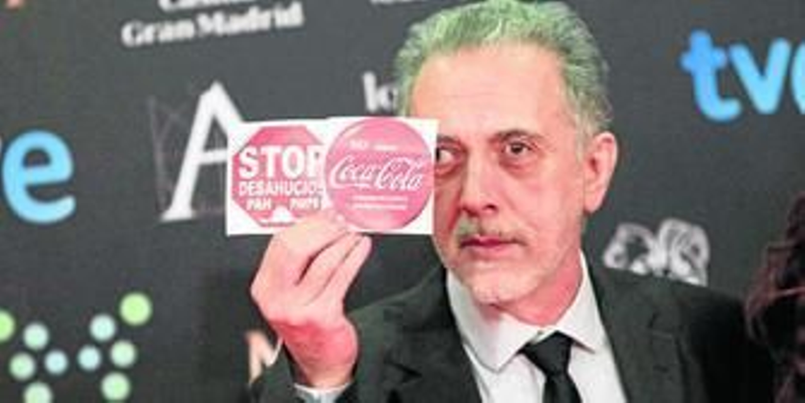 Fernando Trueba muestra carteles de apoyo a la plataforma antidesahucios y a los trabajadores de Coca-Cola.