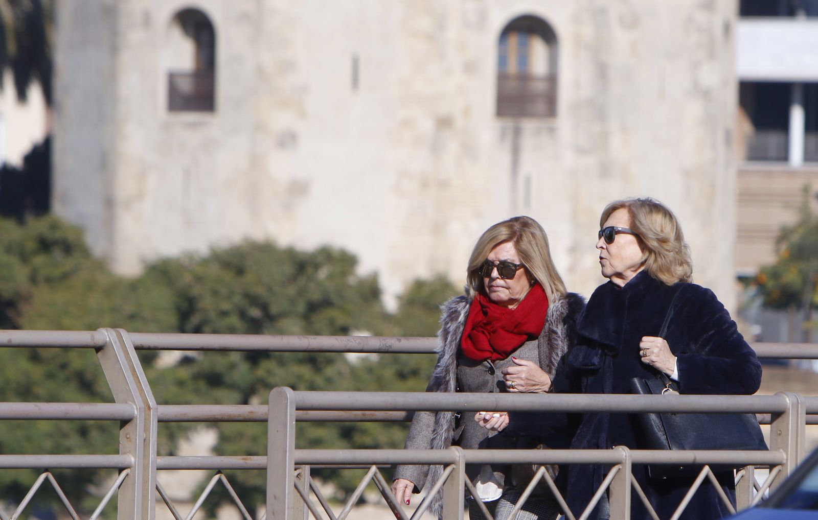 Dos señoras pasean, bien abrigadas, cerca de la Torre del Oro.