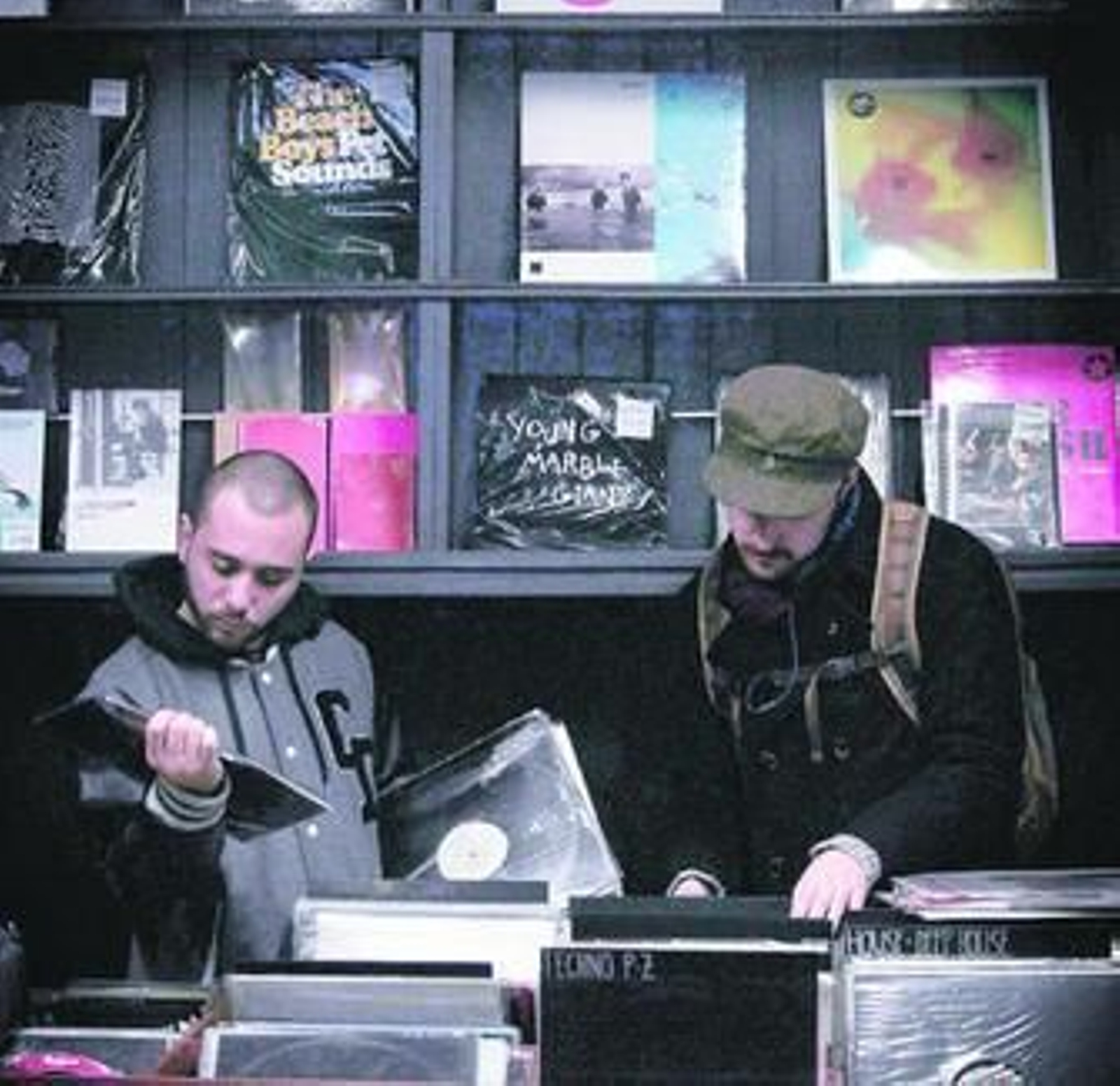 Dos clientes buscan en la sección de vinilos de la tienda.