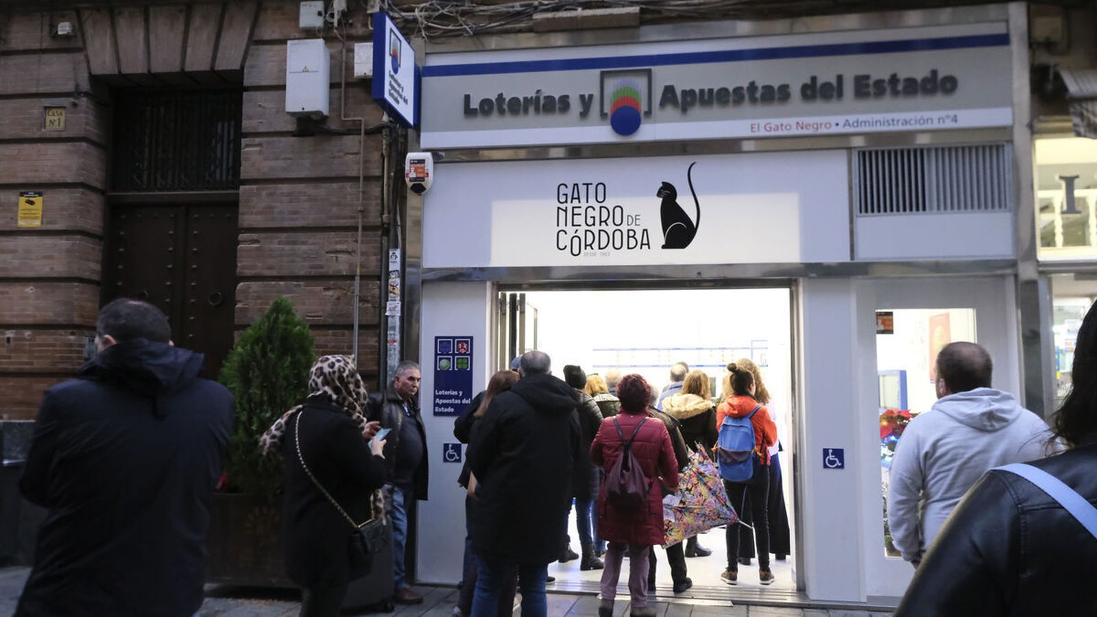 Entrada repleta de personas en la administración de El Gato Negro.