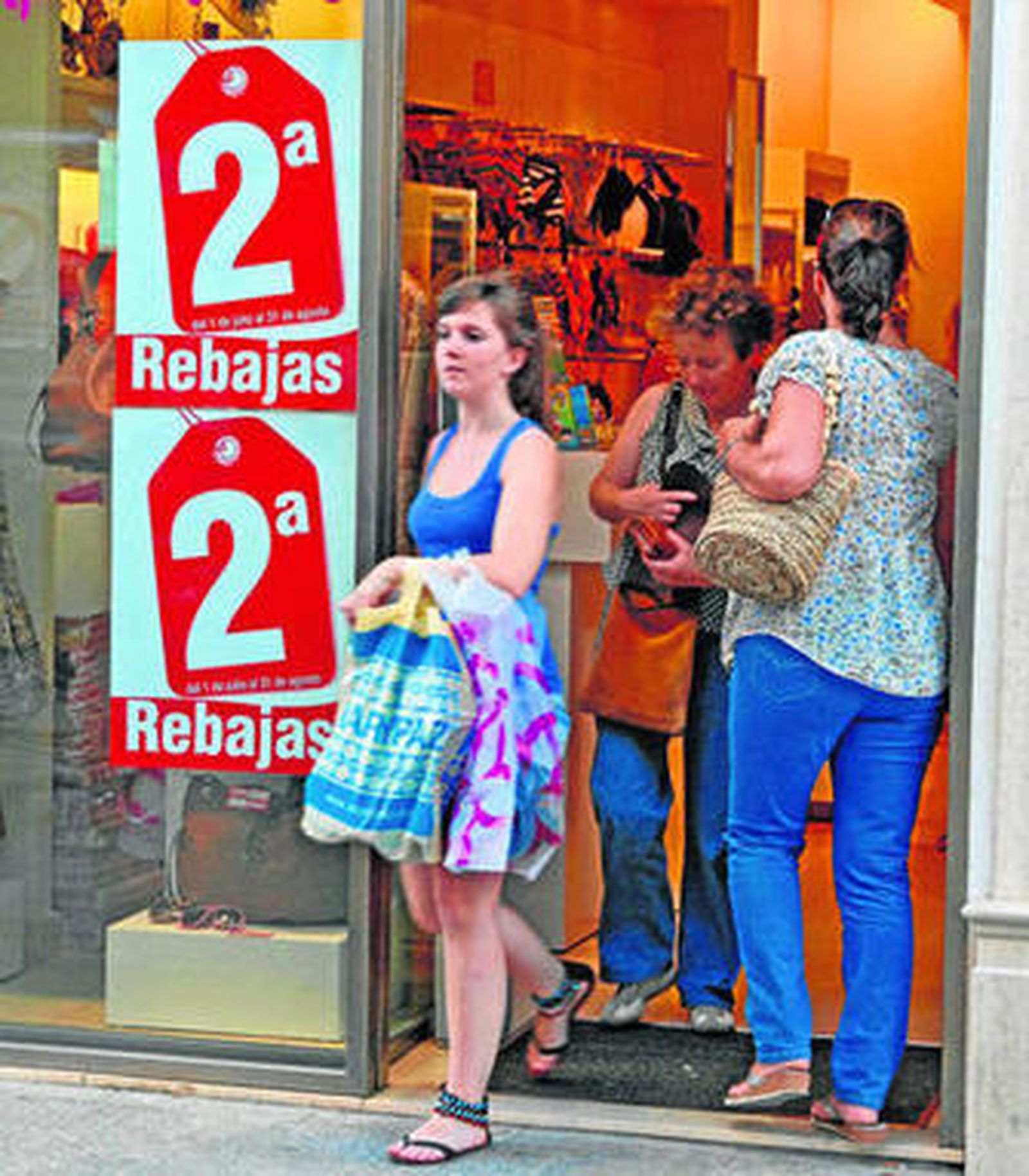 Varias clientas salen de un comercio que ya anuncia las segundas rebajas.