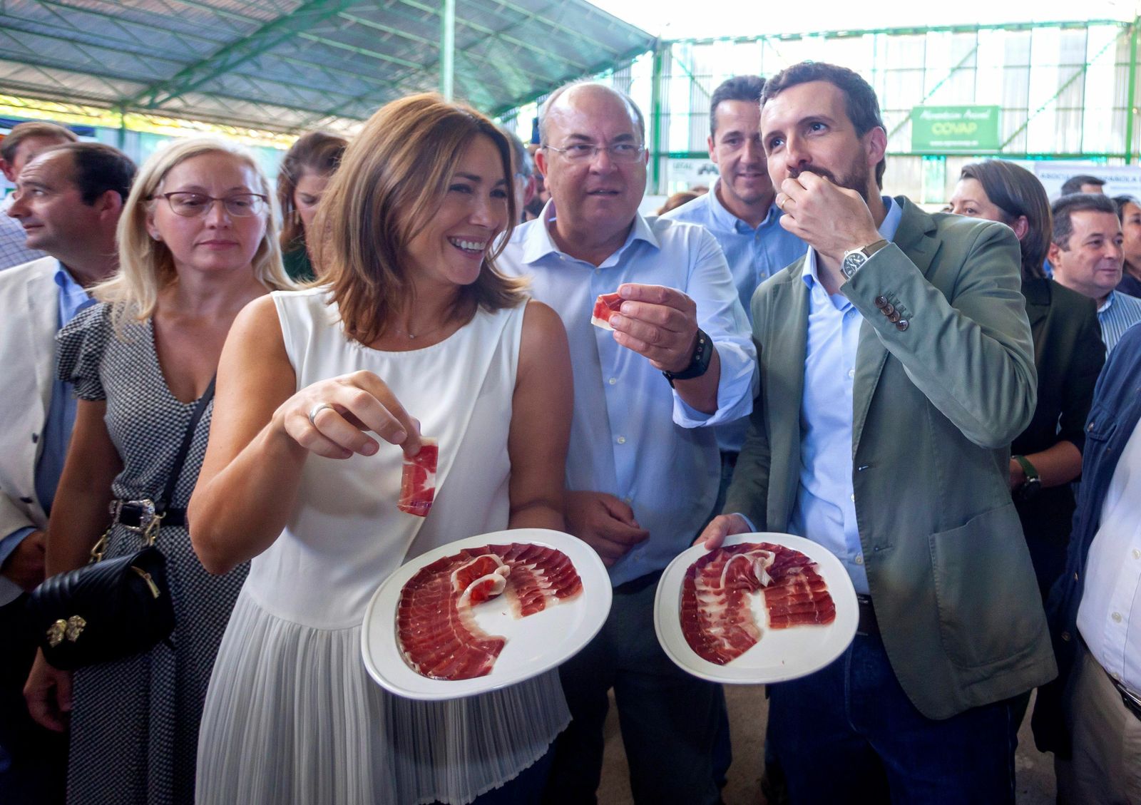 Pablo Casado y el líder del PP extremeño, José Antonio Monago, degustan ayer jamón en la Feria Ganadera de Zafra.