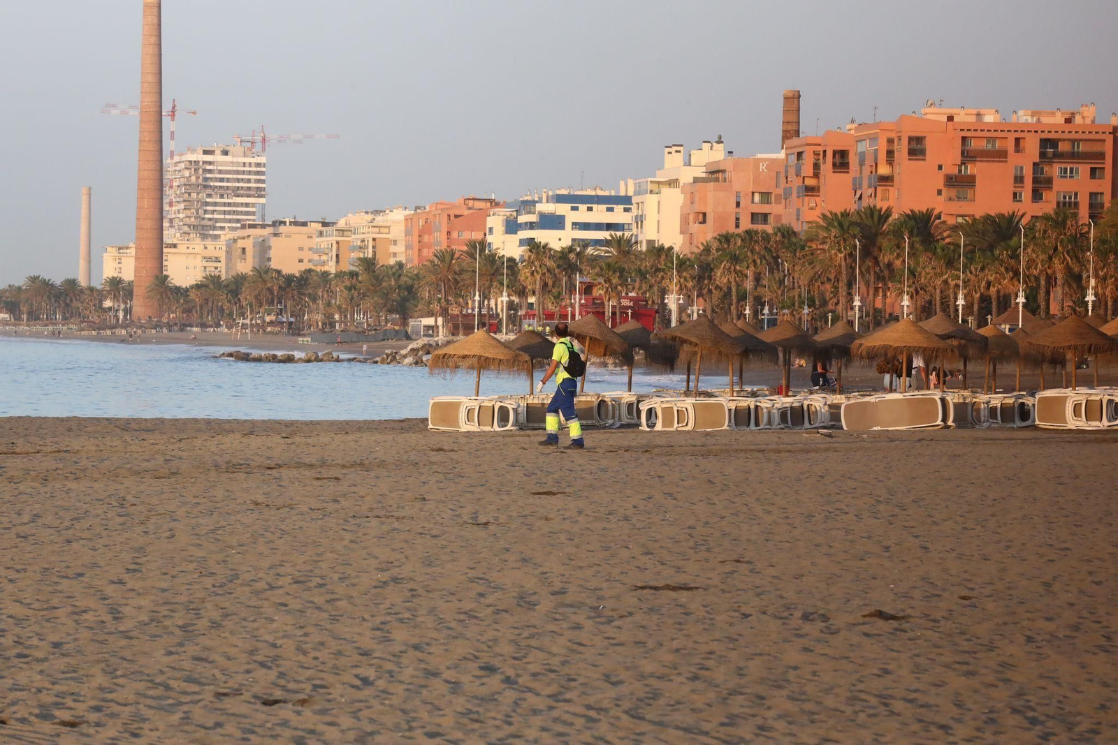 Un operario de limpieza en la playa de Huelin, ya limpia, tras la Noche de San Juan.