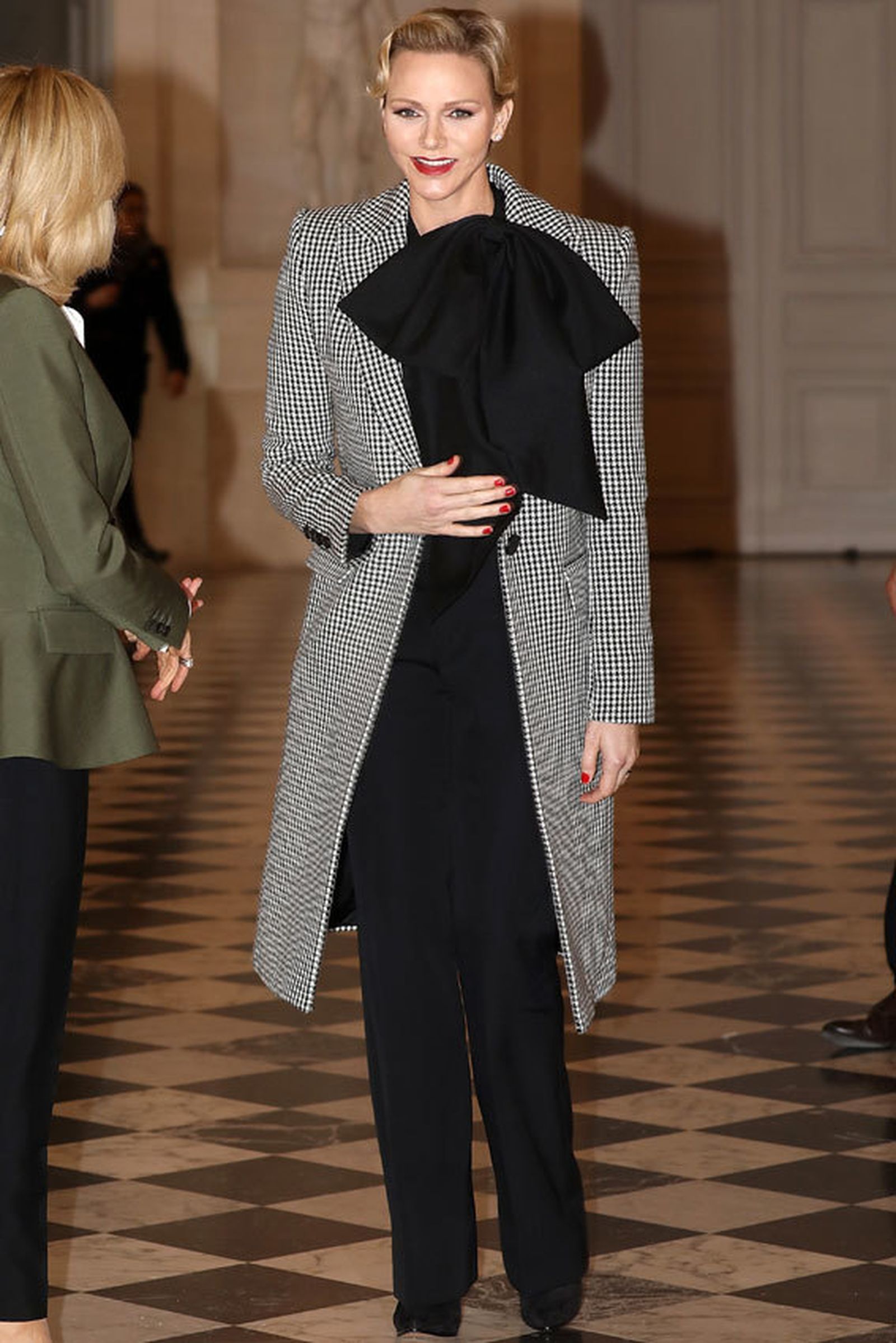 La princesa Charlene, con una blusa negra con gran lazada.