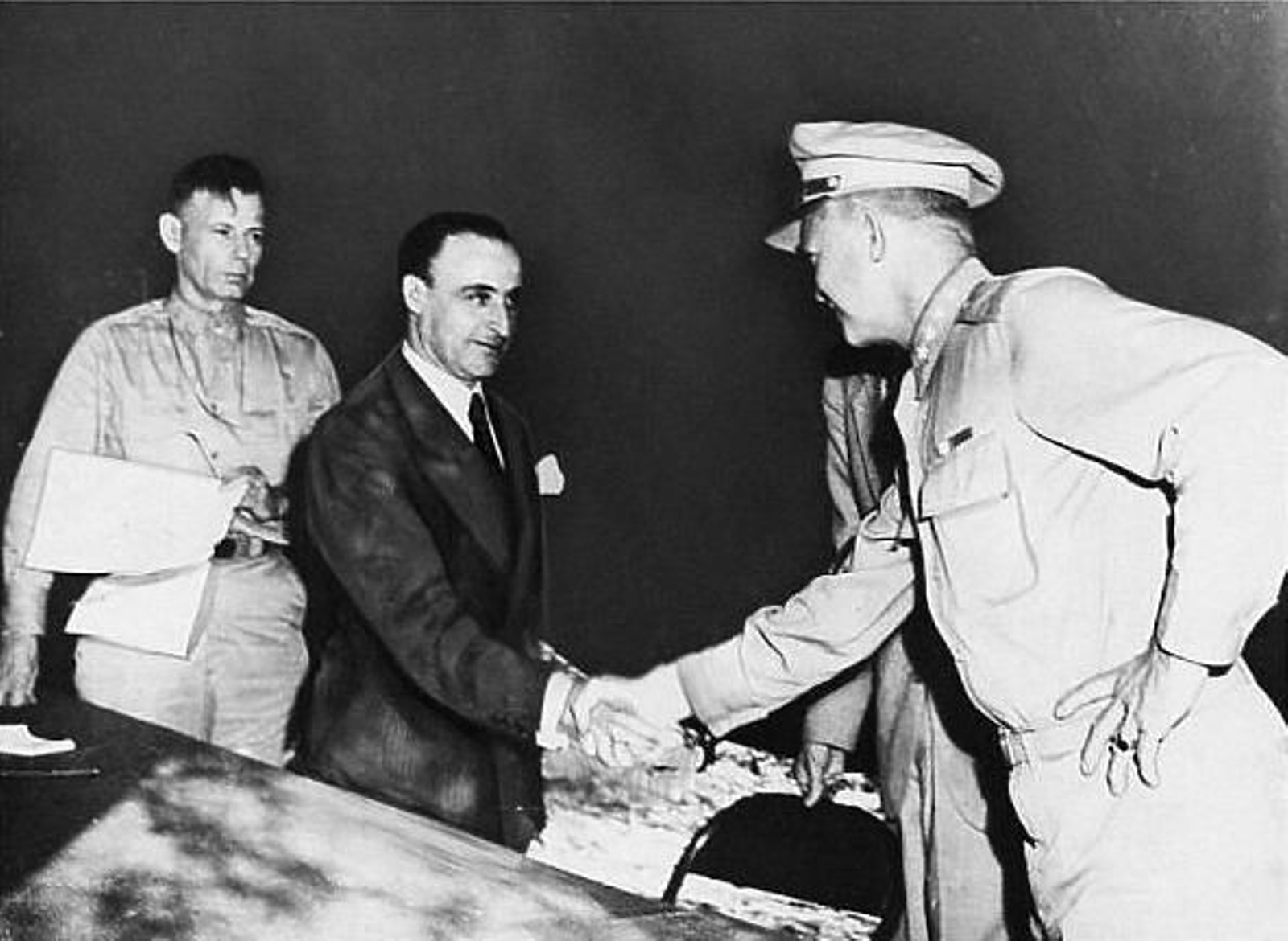 El General Giuseppe Castellano estrecha la mano del Comandante en Jefe de las Fuerzas aliadas en Europa,  General Dwight D. Eisenhower, en la tienda donde acababa de firmar el llamado Armisticio de Cassibile. Tras él,  aparece el General Walter Bedell Smith, firmante del mismo por parte aliada.