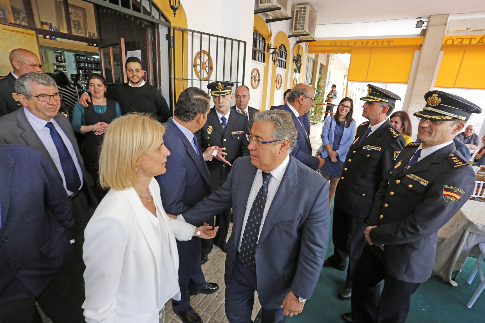Zoido conversa con María José García-Pelayo bajo la mirada del comisario en un bar cercano a la Cámara de Comercio.