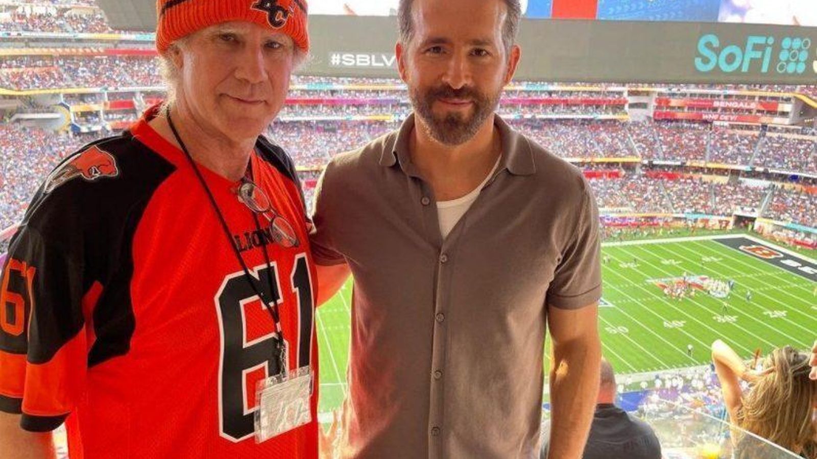 Ryan Reynolds con el también actor Will Ferrel, con el campo de fondo.