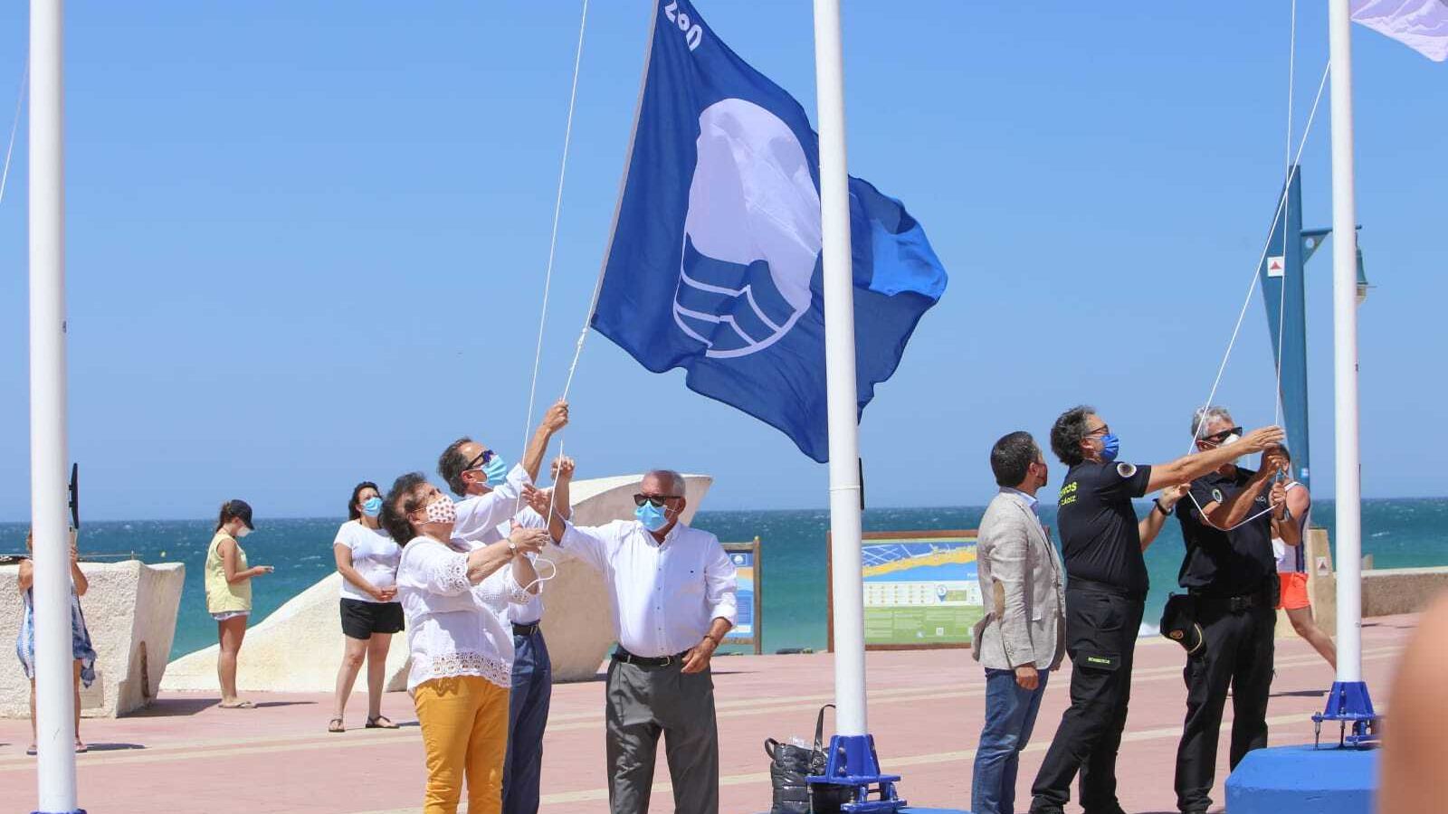Momento en el que el alcalde, Manolita Fernández y Antonio Piñero izan la Bandera Azul.