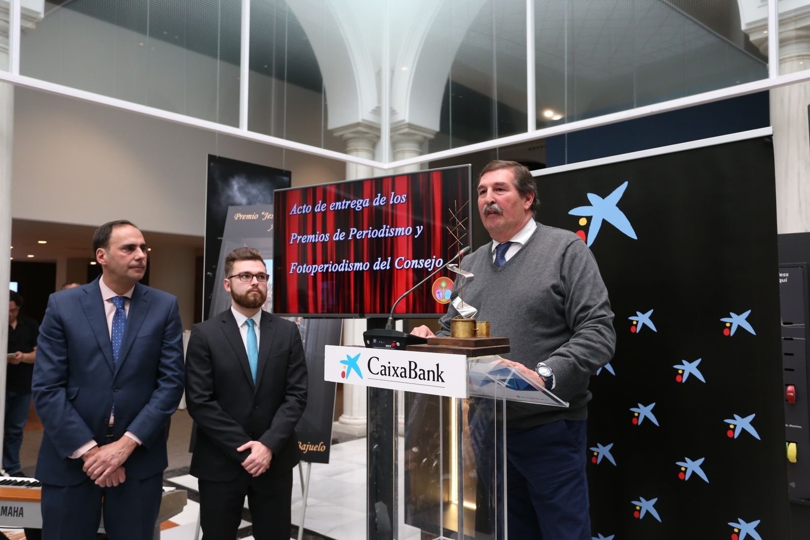 Félix Machuca, tras recibir el premio, con el hermano y el hijo de Fernando Carrasco.