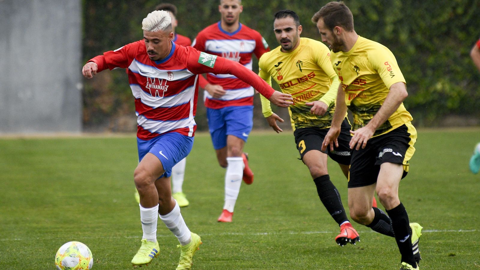 Viedma conduce el balón con la presencia de dos rivales