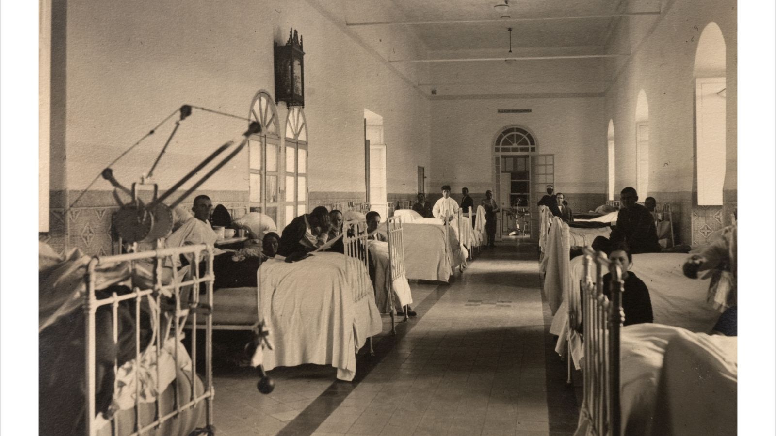 Enfermos en sus camas junto a  familiares en una de las grandes habitaciones compartidas del Hospital de las Cinco Llagas.