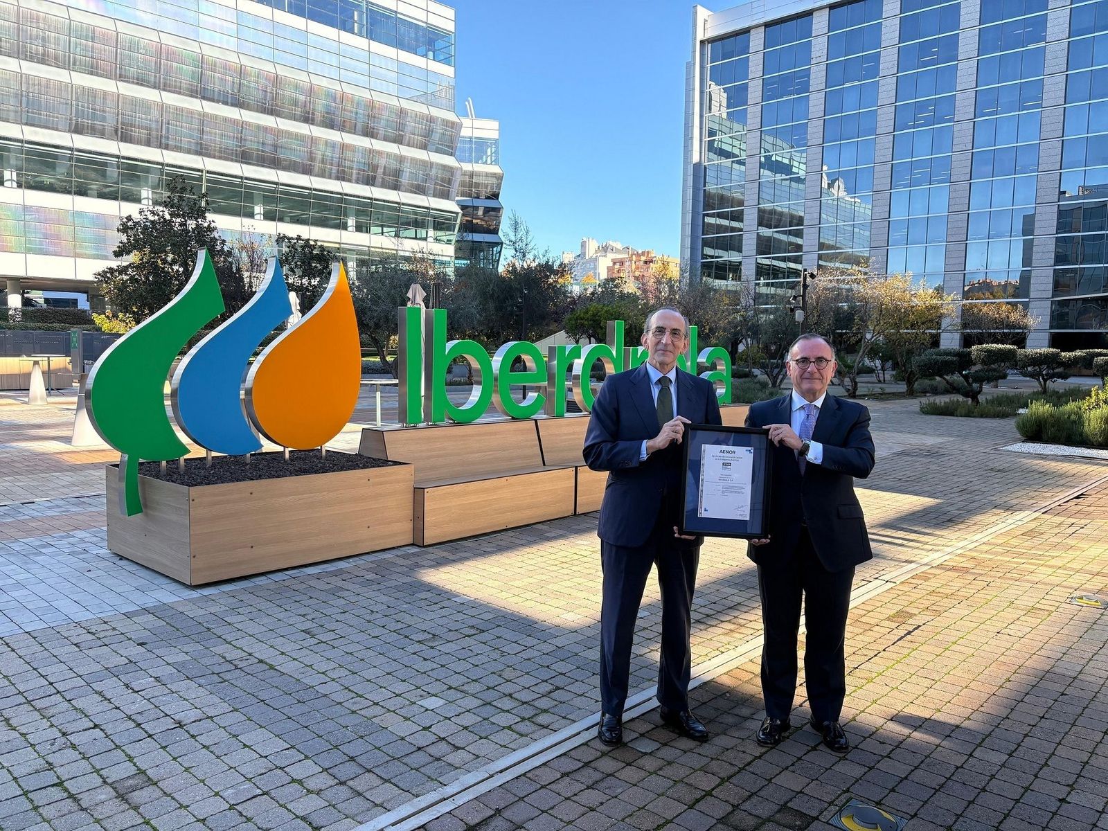 Responsables de la compañía muestran con orgullo el certificado de Aenor