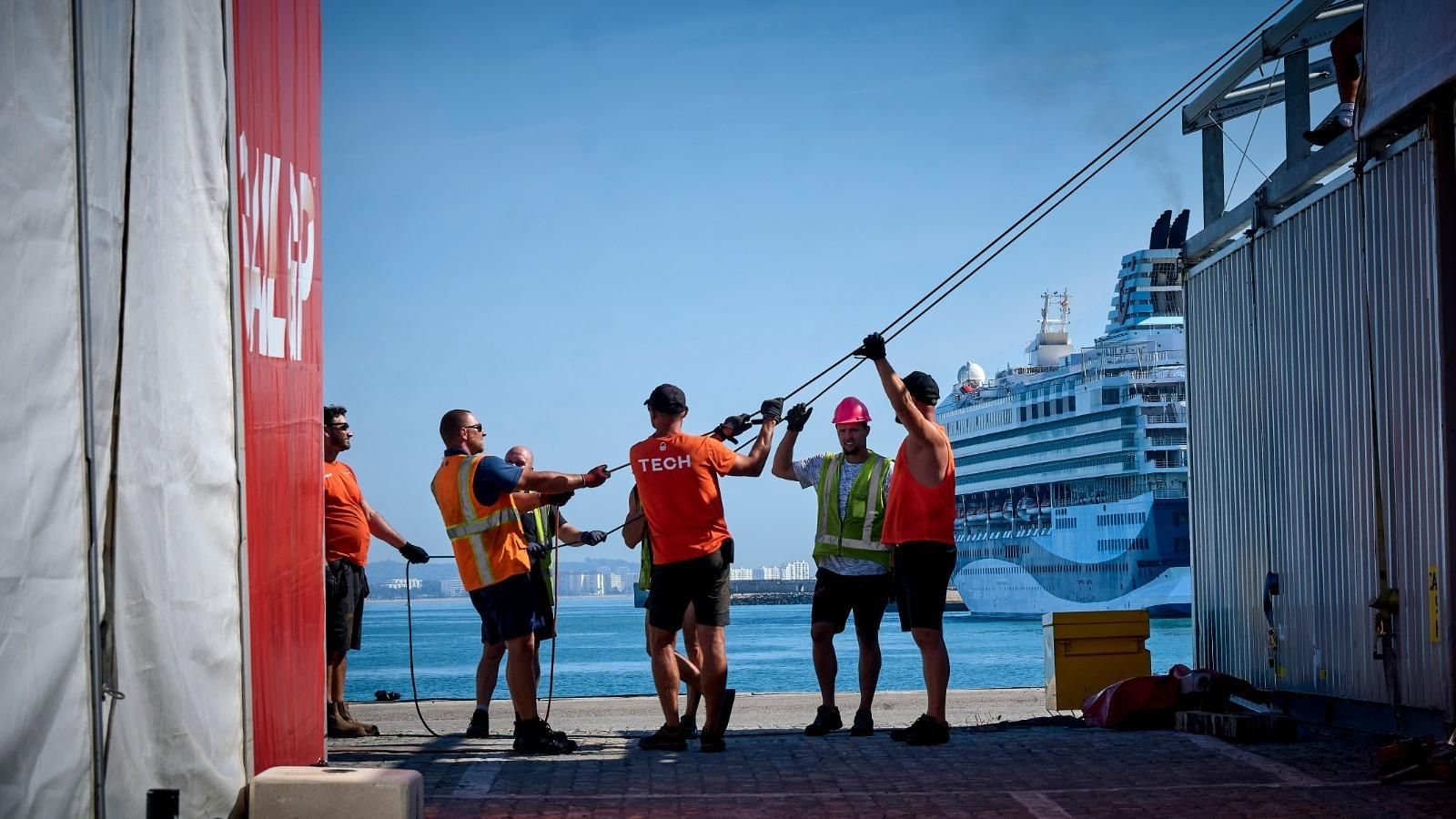 Varios trabajadores montan una carpa para el Sail GP, este lunes, con el Marella Explorer al fondo