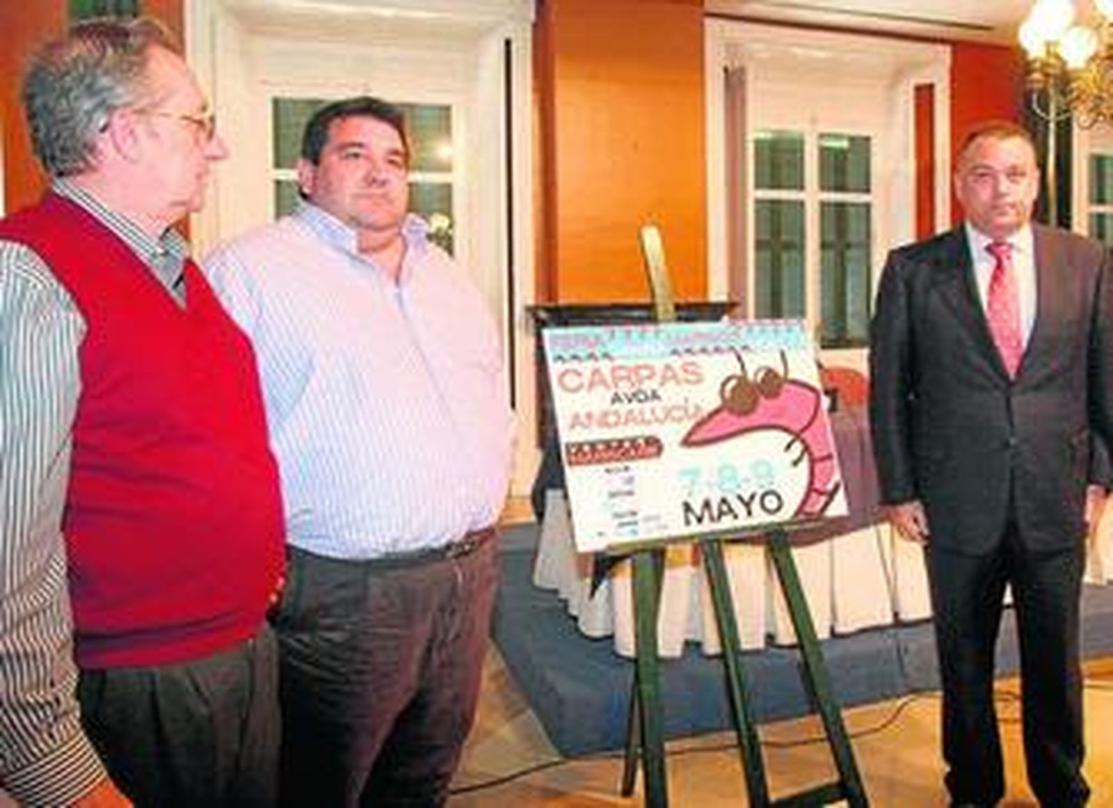 Manuel Márquez, Bernardo Pelayo y Juan Carlos Adame, junto al cartel de la Feria de la Gamba.