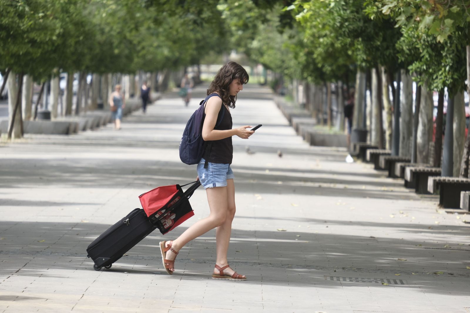 Una joven camina sola por el bulevar de Gran Vía Parque.