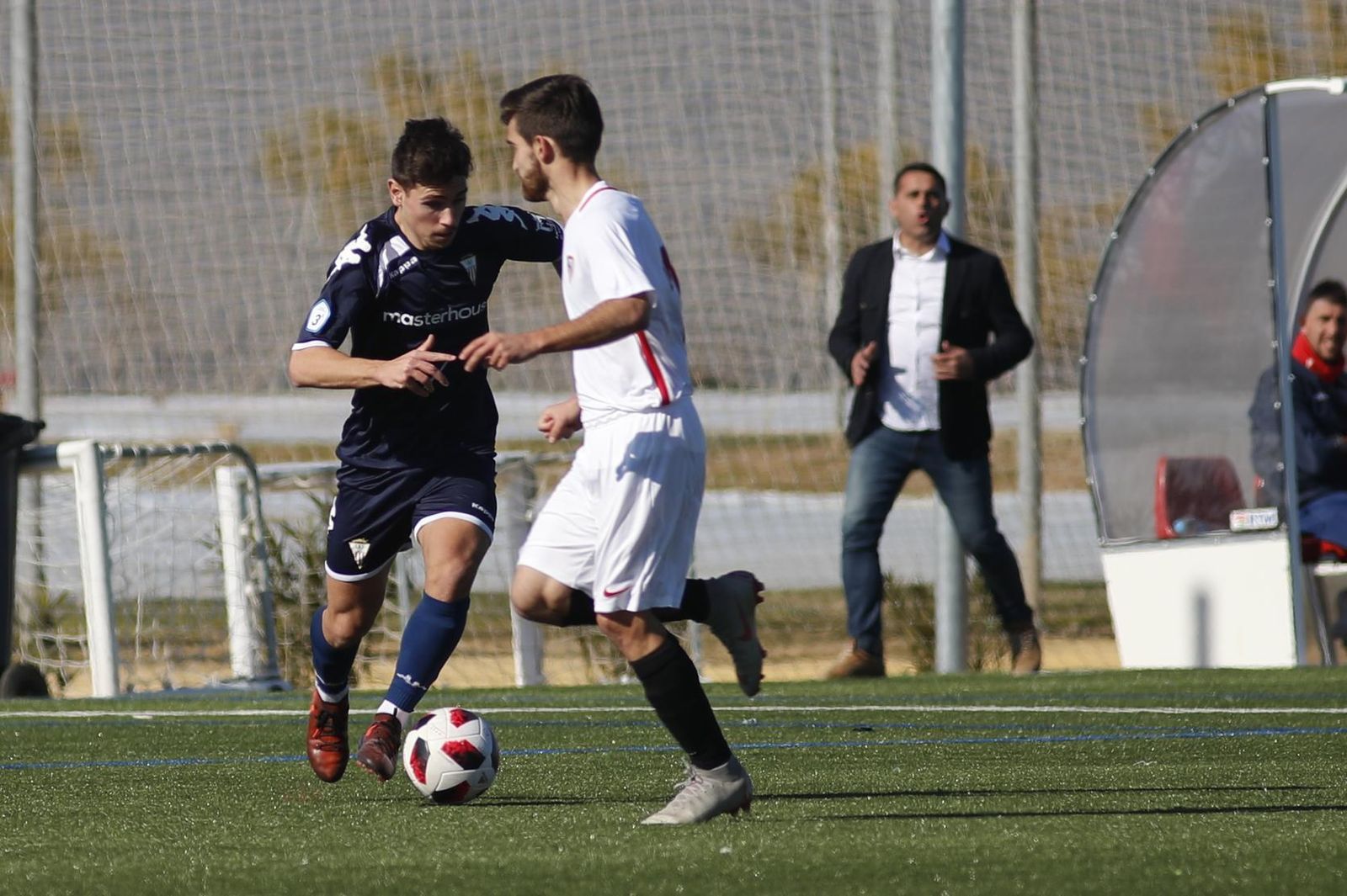 Alberto Fuentes conduce el balón en Sevilla, con Fajardo al fondo.