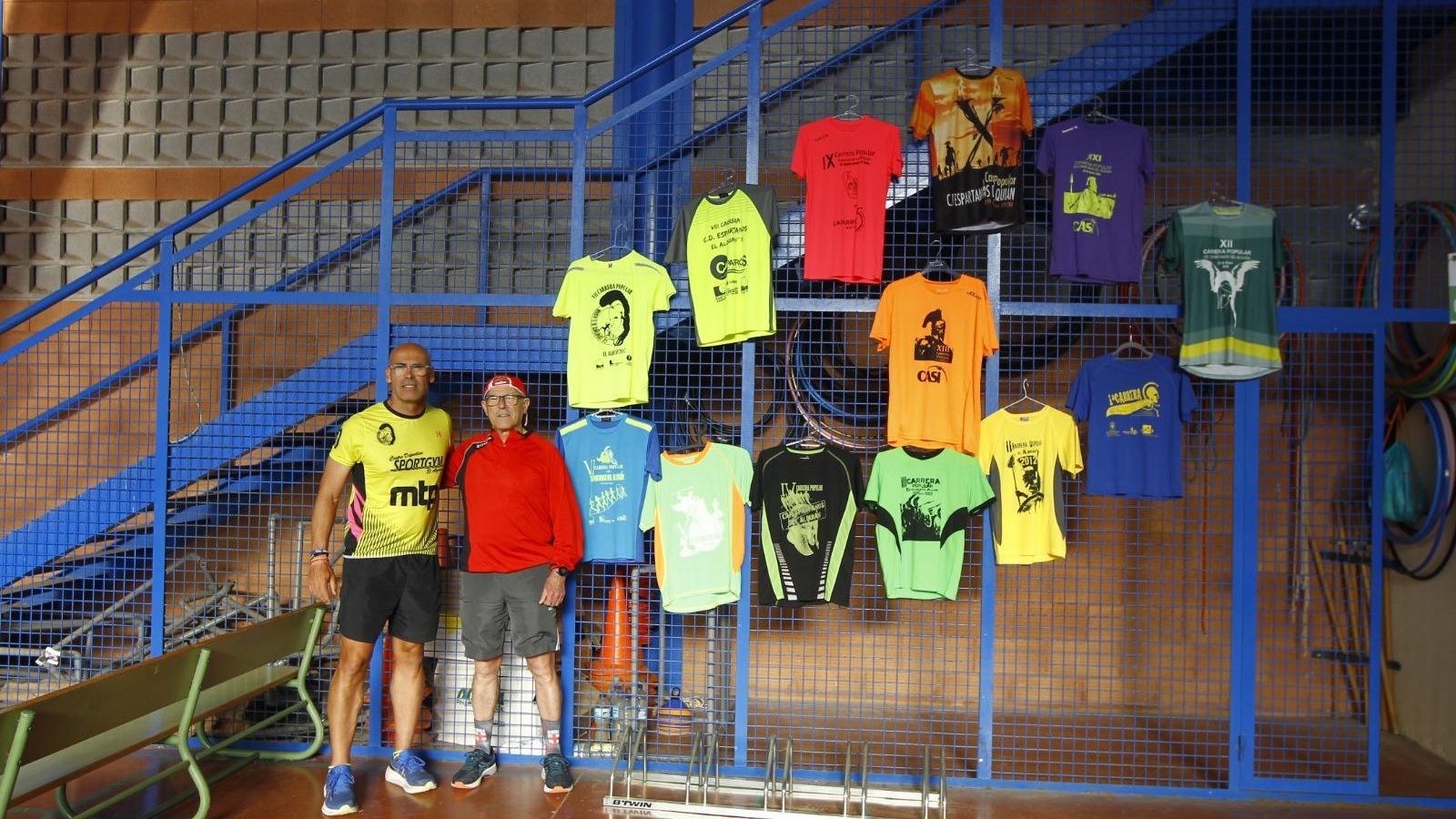 Emilio Baeza y otro de los corredores posan junto a las camisetas de ediciones anteriores.