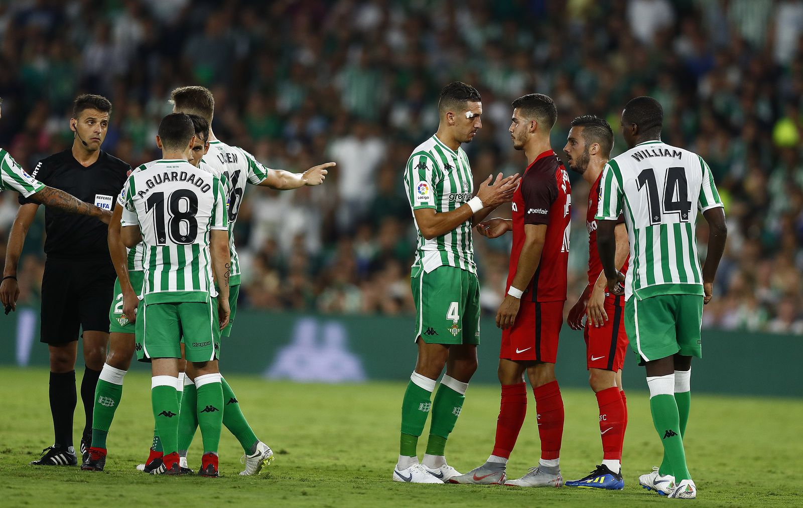 Gil Manzano, ante varios jugadores del Betis y el Sevilla en el derbi de septiembre de 2018.