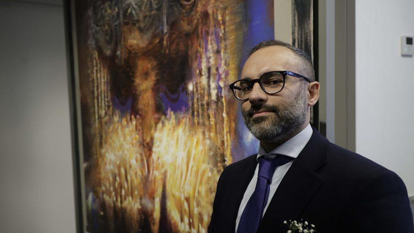 Daniel Franca junto al cartel que  ha pintado para anunciar la Semana Santa de Sevilla.