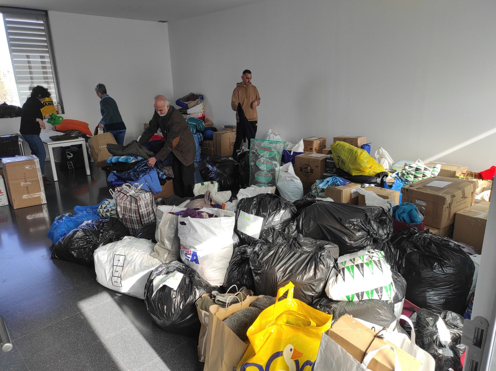 Voluntarios turcos reciben y clasifican la ropa donada por los ciudadanos de Granada