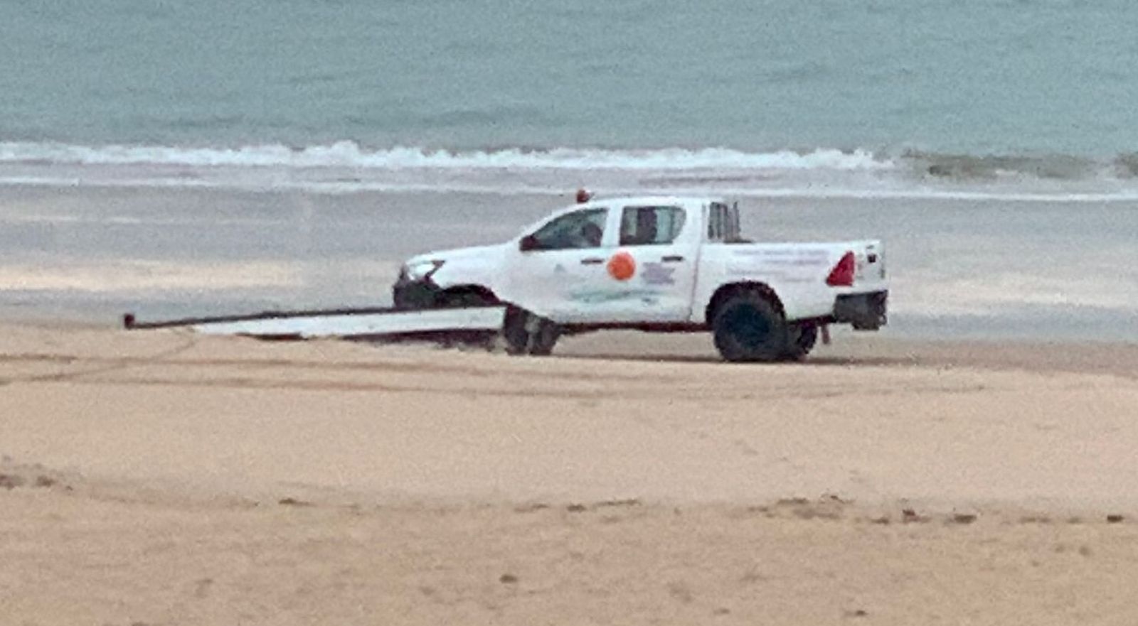 Los servicios de playas, retirando la embarcación de la playa.
