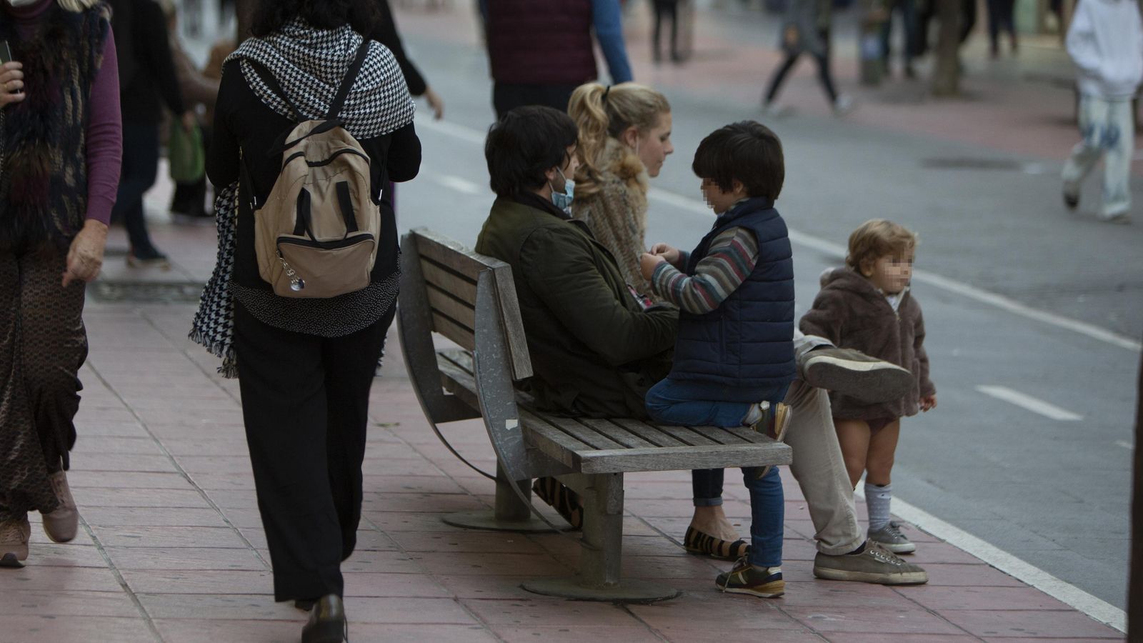 Una familia sentada en uno de los escasos bancos de la zona.