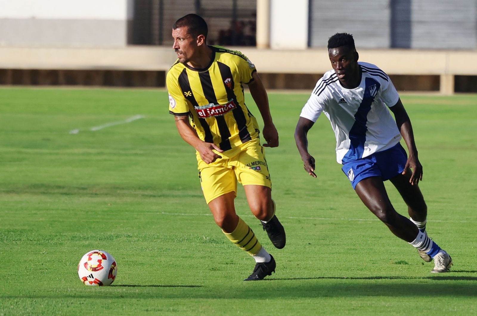 Jesús Rueda conduce la pelota perseguido por Cheikh.