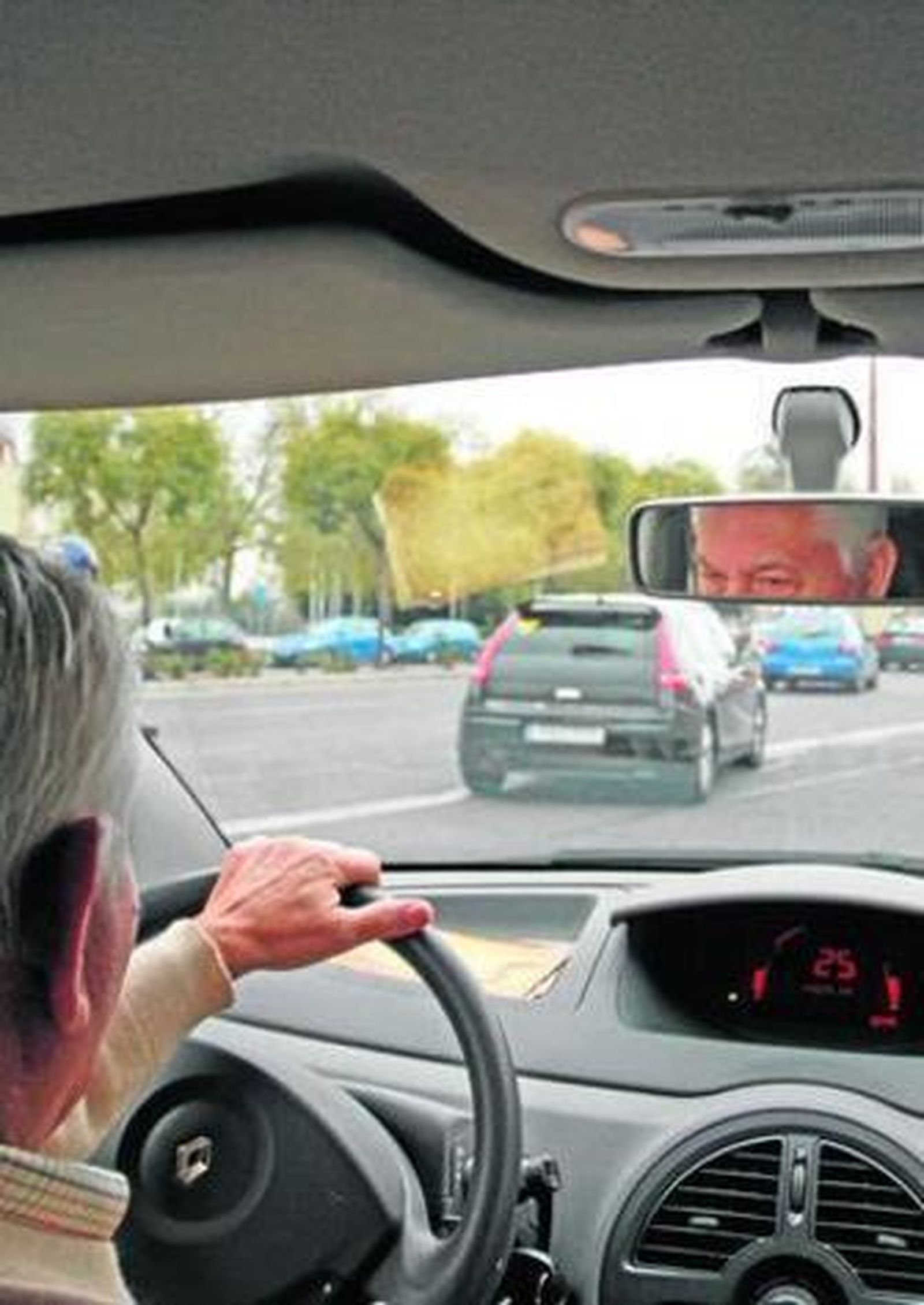 Un conductor circula con su vehículo por una vía urbana.