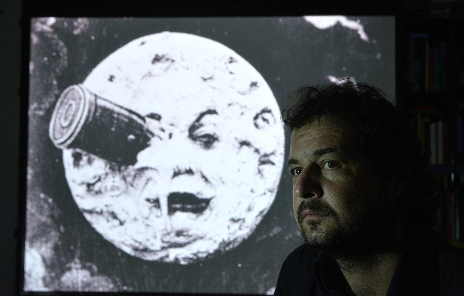 David Eloy Rodríguez (Cáceres, 1976), junto a una de las imágenes icónicas del largometraje de Méliès 'Viaje a la luna'.
