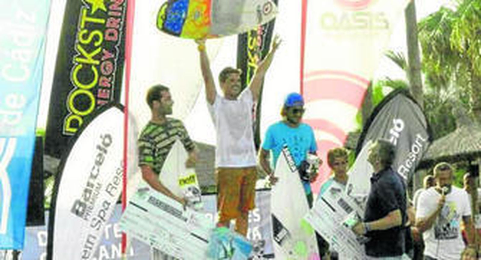 El deportista chiclanero, Emilio Oliva Pacheco, levanta su tabla tras proclamarse vencedor.