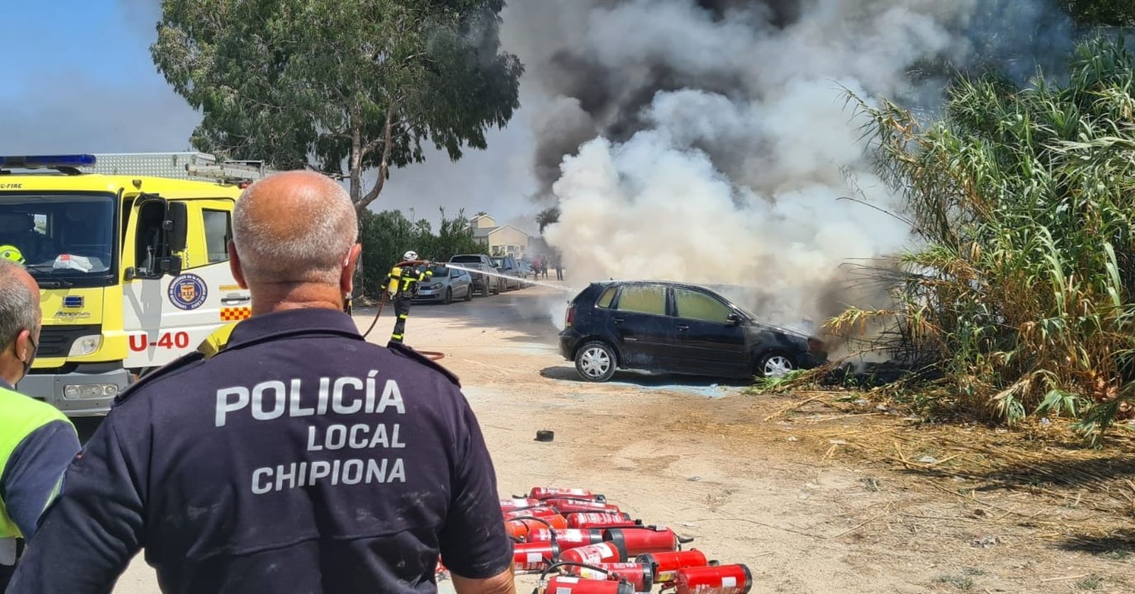 Un momento de la extinción del incendio de varios vehículos en una playa de Chipiona.