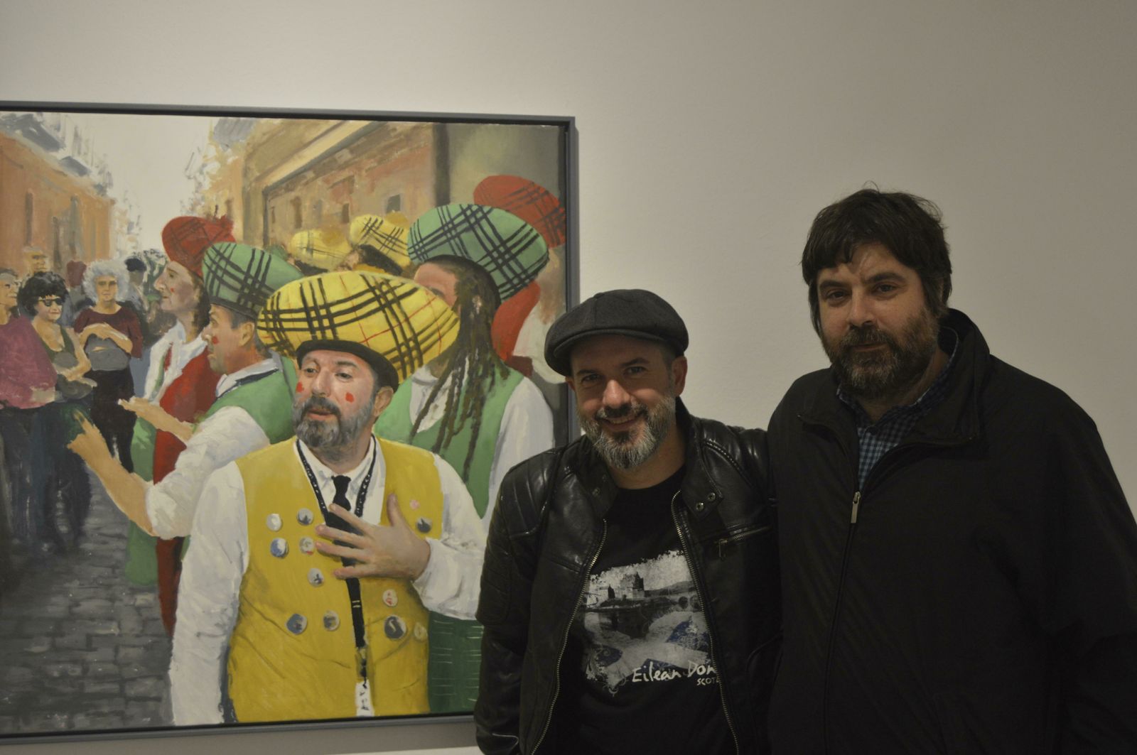 José Luis Porquicho junto a su retrato, con el pintor Pepe Baena, en la sala de exposición de la Fundación Cajasol.