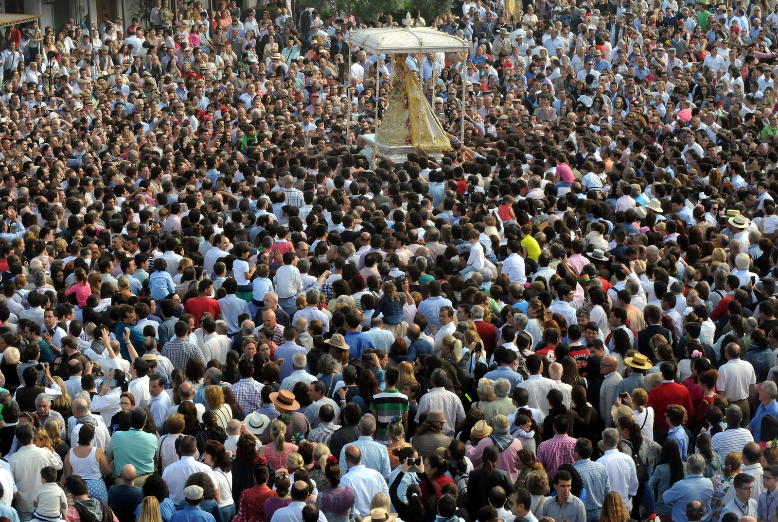 Un mar de personas acompañan a la Virgen del Rocío en su procesionar por la aldea almonteña.