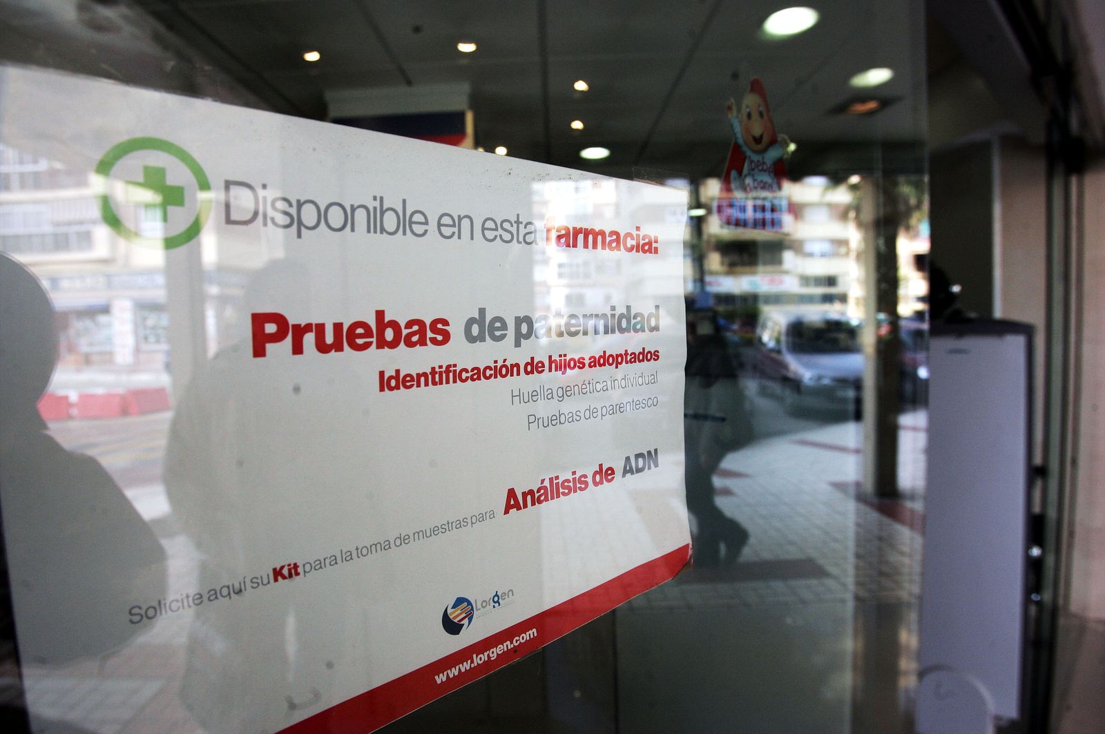 Un cartel anuncia pruebas de paternidad en una farmacia.