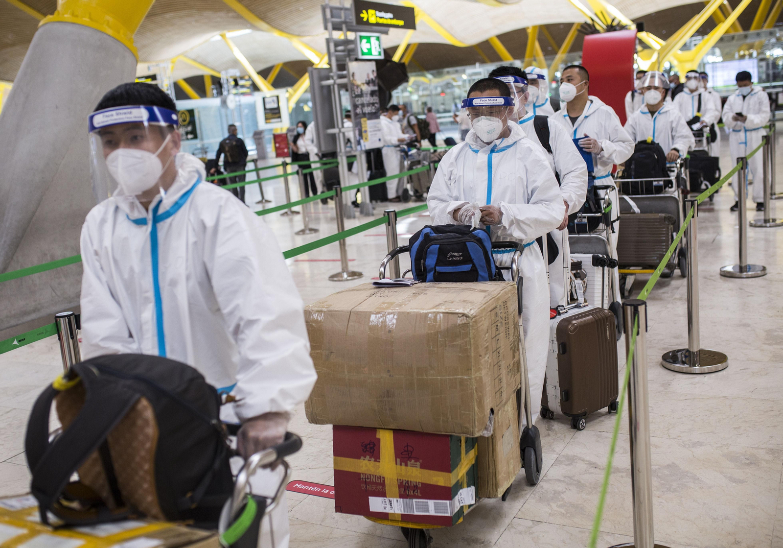 Trabajadores procedentes de China con trajes de protección ayer en la terminal T4 del aeropuerto de Madrid-Barajas. Trabajadores procedentes de China con trajes de protección ayer en la terminal T4 del aeropuerto de Madrid-Barajas.