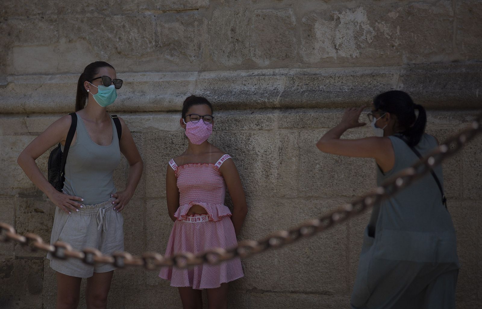 Dos mujeres y una menor se sacan fotografías junto a la Catedral de Sevilla.