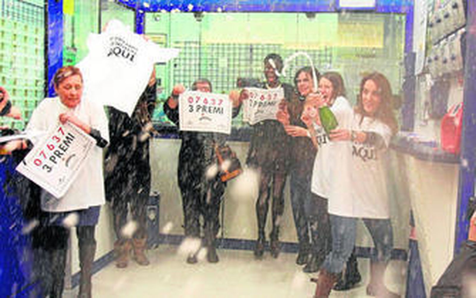 La lotera del centro comercial celebra junto a sus empleadas su suerte.
