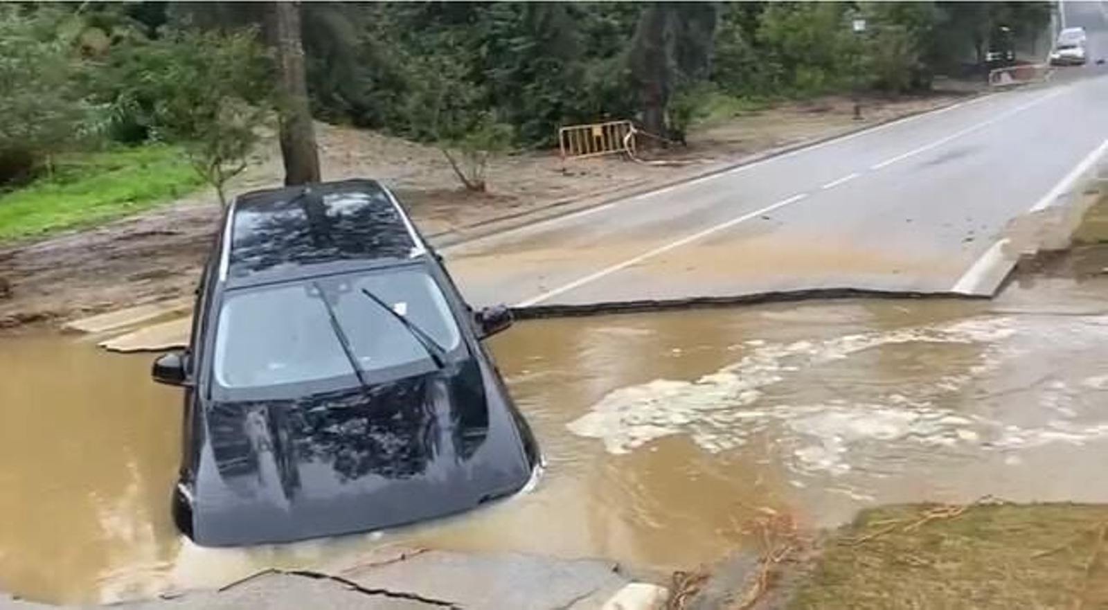 Un coche, en el agujero que se ha creado en la avenida de Los Cortijos, en Sotogrande