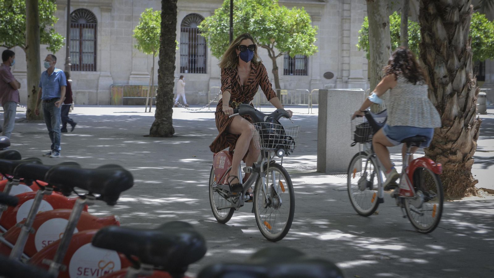 Dos mujeres se cruzan usando el Sevici a escasos metros de la Casa Consistorial.