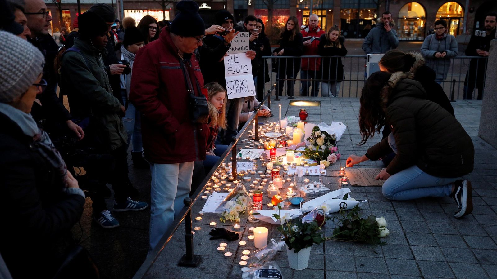 Ciudadanos encienden velas donde falleció una de las víctimas del atentado en Estrasburgo.