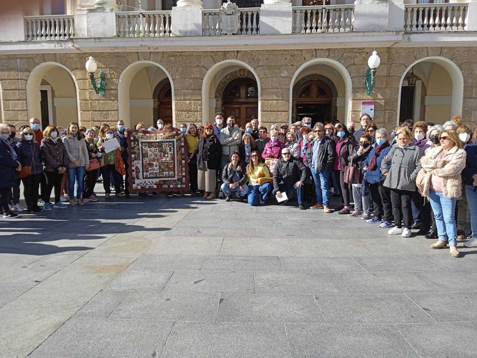 Usuarios de los talleres y monitores concentrados ante la puerta del Ayuntamiento de Cádiz.
