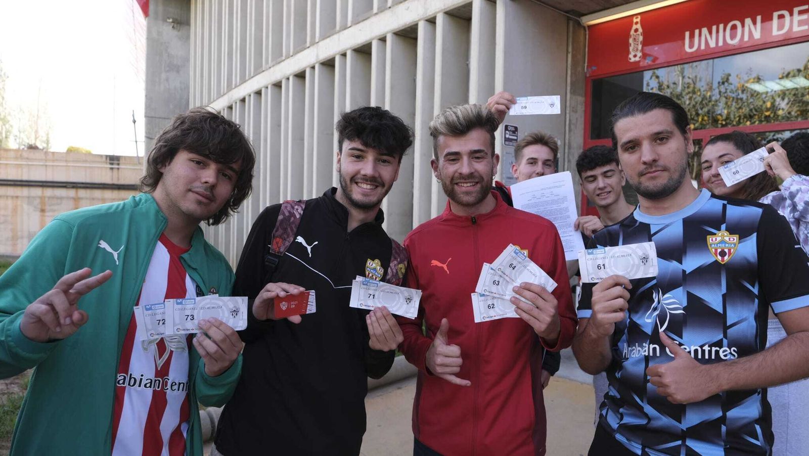 Varios jóvenes aficionados rojiblancos con los tickets para recoger sus entradas dentro de la sed