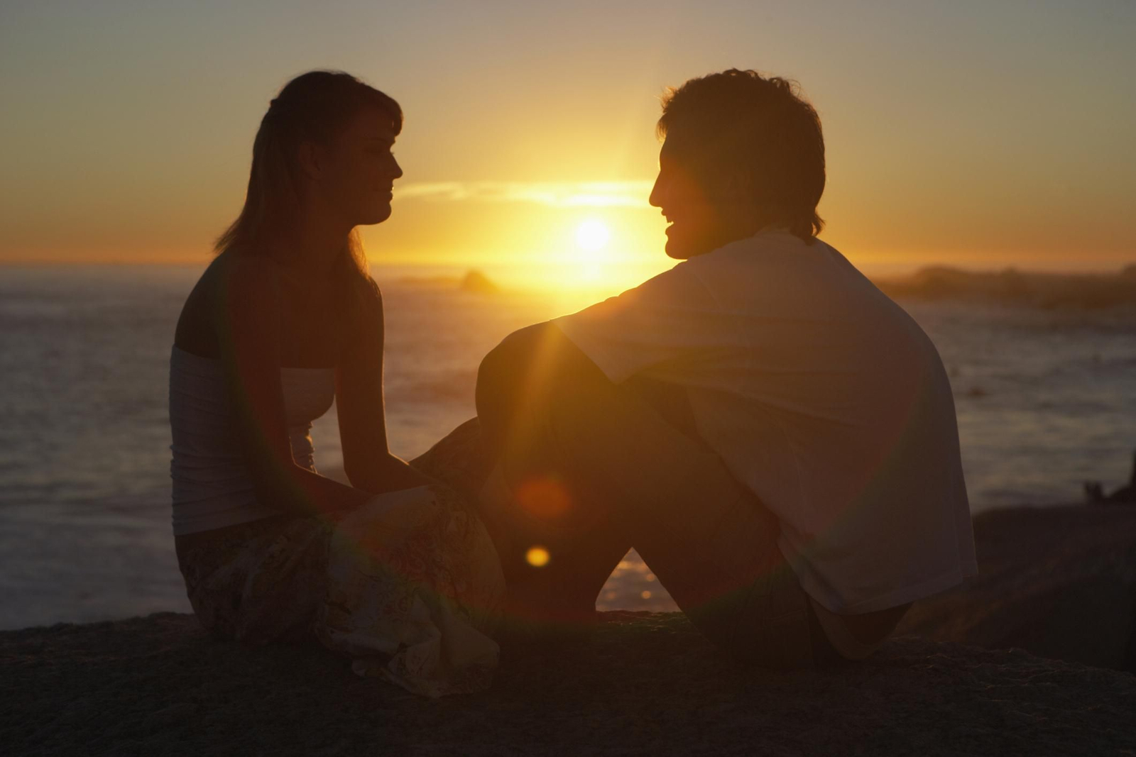 Una pareja en una puesta de sol en la playa Una pareja en una puesta de sol en la playa