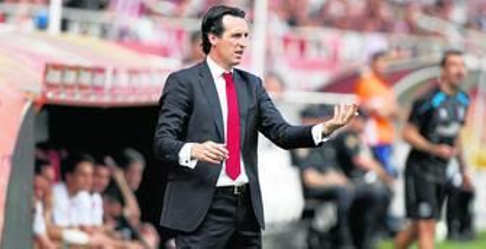 Unai Emery realiza un gesto en la banda del Ramón Sánchez-Pizjuán mientras su ayudante, Juan Carlos Carcedo, se degañita al fondo.
