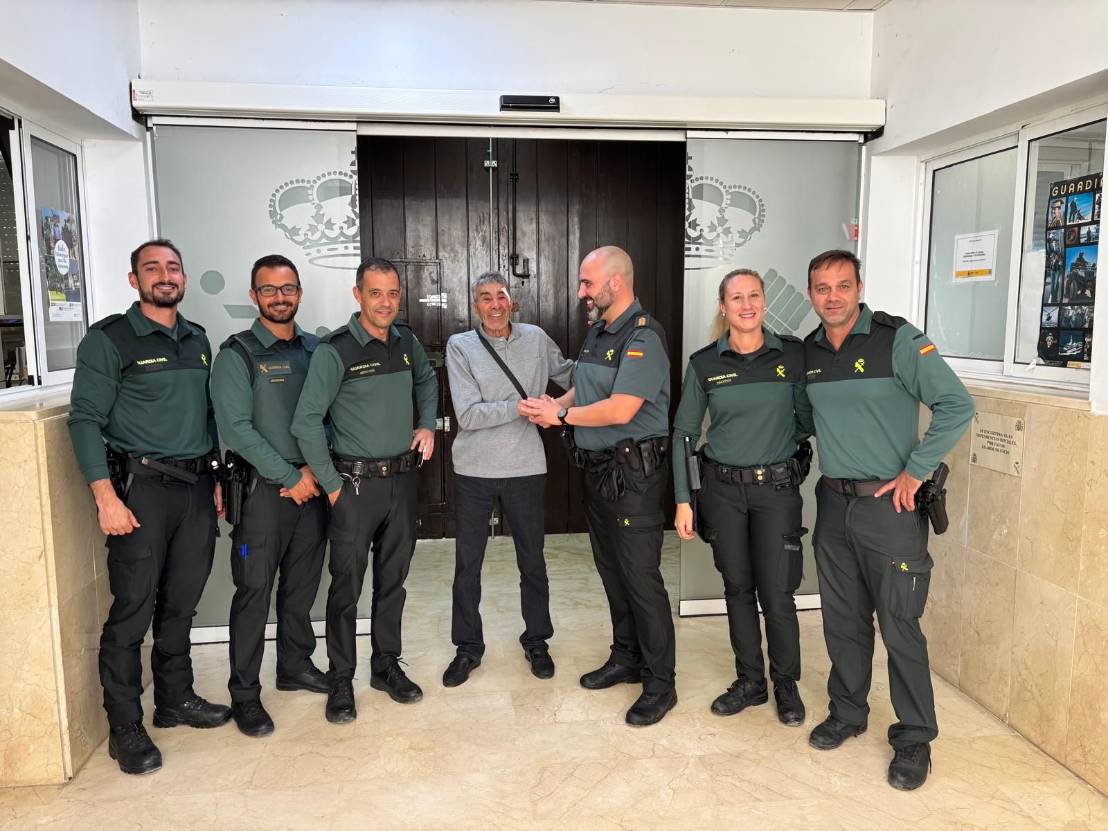 Los agentes de la Guardia Civil posan junto al anciano antes de reencontrarse con sus familiares.