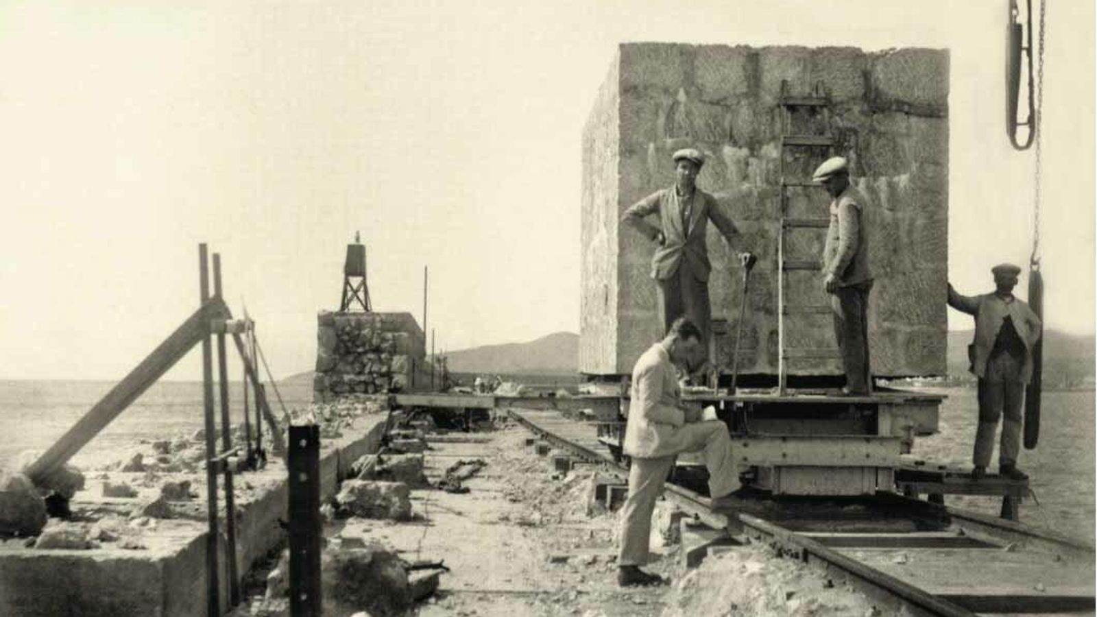 El carro transbordador portando un bloque hasta las proximidades del Titán. A la izquierda, el espaldón del rompeolas en construcción. Sobre 1927.