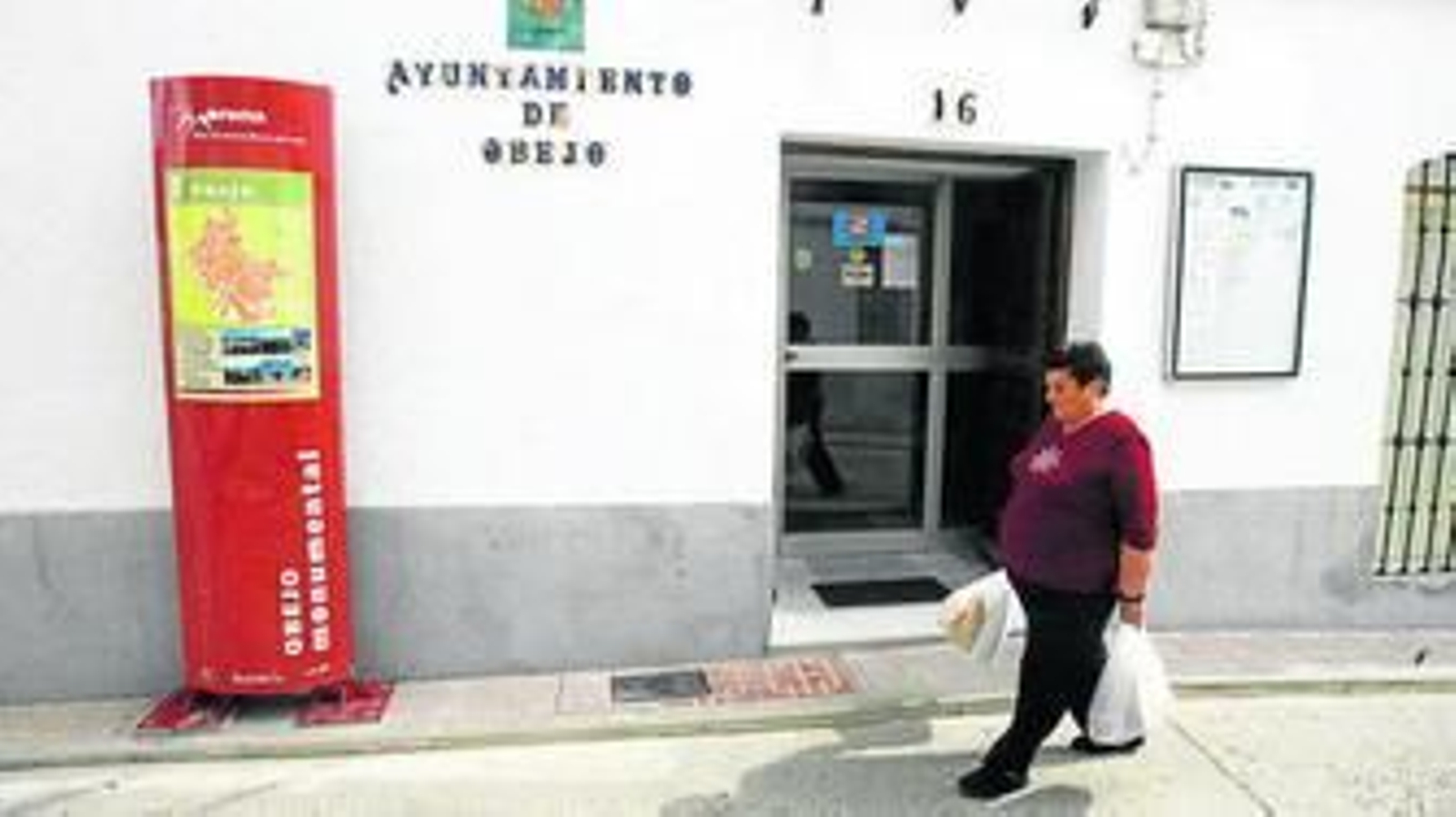 Una señora pasa por delante de la fachada del Ayuntamiento de Obejo