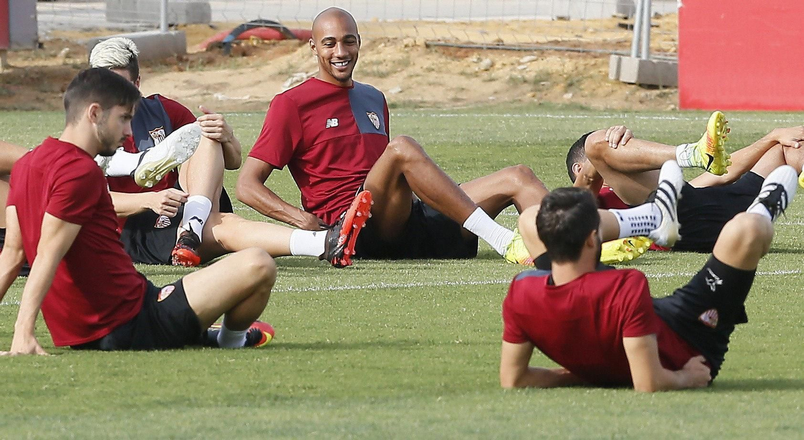 N'Zonzi, sonriente, realiza estiramientos frente a Sarabia y Pareja, sobre el césped de la ciudad deportiva.