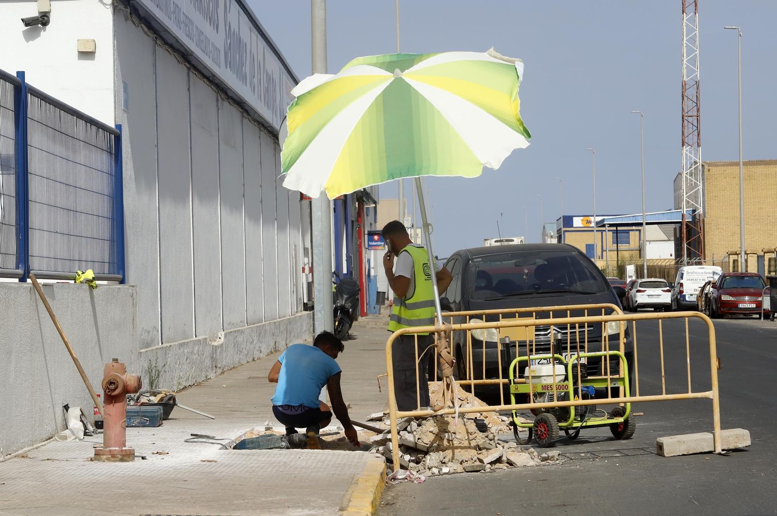 Dos trabajadores se protegen como pueden contra las altas temperaturas en Huelva.